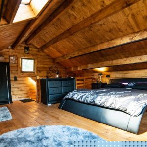 Chalet en bois chaleureux avec lit king-size et ambiance cosy en Auvergne-Rhône-Alpes.