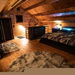 Chalet en bois avec lit moderne, ambiance chaleureuse et décoration cosy.