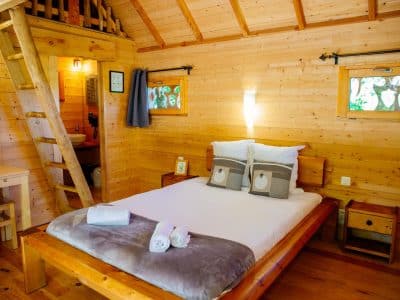 Cabane en bois chaleureuse avec lit douillet et décoration naturelle.