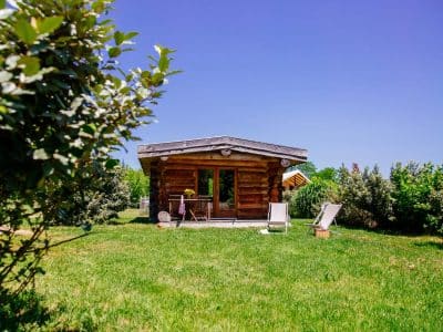 Cabane en bois dans un jardin verdoyant, idéale pour un séjour insolite en Aquitaine.