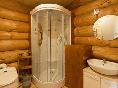 Salle de bain en bois dans un hébergement insolite en Aquitaine, avec douche moderne.