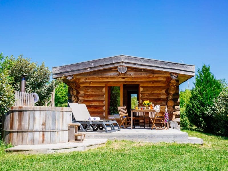 Cabane en bois avec terrasse et jacuzzi, au cœur de la nature en Aquitaine.