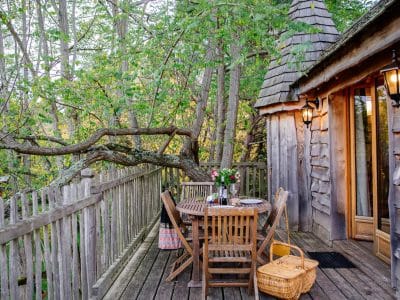 Cabane perchée en Aquitaine avec terrasse en bois et vue sur la nature.