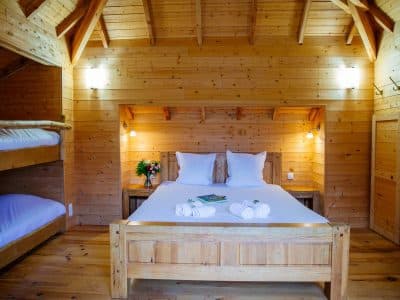 Chalet en bois chaleureux avec lit double et lits superposés, ambiance cosy.