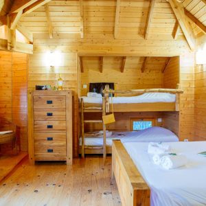 Chalet en bois chaleureux avec lits superposés et décoration en bois naturel.
