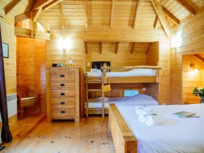 Chalet en bois chaleureux avec lits superposés et décoration en bois naturel.