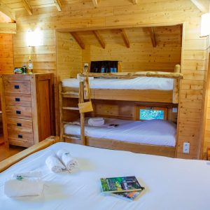 Chalet en bois chaleureux avec lits superposés et décoration naturelle.