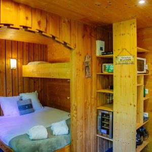 Chalet en bois chaleureux avec lit superposé et décor naturel en Aquitaine.