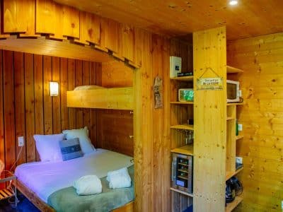 Chalet en bois chaleureux avec lit superposé et décor naturel en Aquitaine.