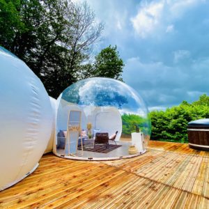 Bulle transparente en Basse-Normandie, avec terrasse en bois et jacuzzi à proximité.