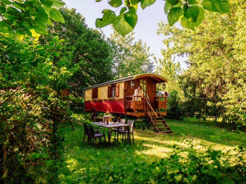 Charmante roulotte colorée entourée de verdure, idéale pour un séjour insolite en Aquitaine.