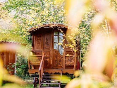 Charmante roulotte en bois, nichée dans la verdure dAquitaine, idéale pour un séjour insolite.