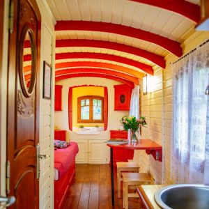 Hébergement insolite en Aquitaine : roulotte colorée avec intérieur en bois chaleureux.