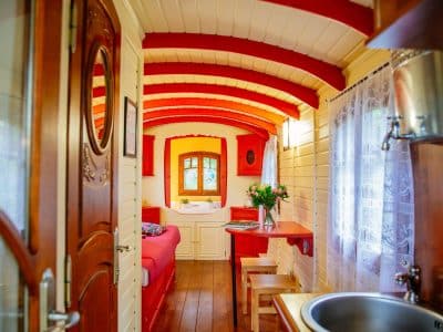 Hébergement insolite en Aquitaine : roulotte colorée avec intérieur en bois chaleureux.