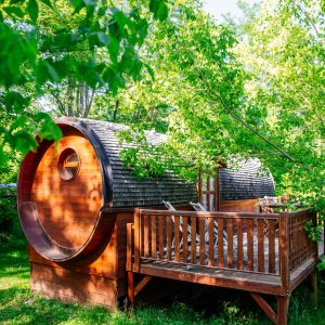 Hébergement insolite en Aquitaine : cabane ronde en bois entourée de verdure.