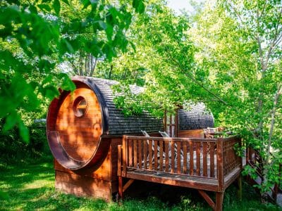 Hébergement insolite en Aquitaine : cabane ronde en bois entourée de verdure.