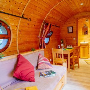 Hébergement insolite en Aquitaine : un intérieur en bois chaleureux avec fenêtres rondes.