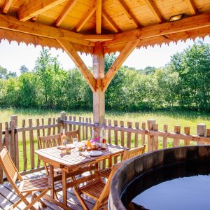 Hébergement insolite en Aquitaine : cabane en bois avec jacuzzi et vue sur la nature.