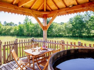 Hébergement insolite en Aquitaine : cabane en bois avec jacuzzi et vue sur la nature.