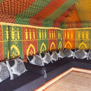 Tente berbère colorée avec coussins noirs, idéale pour un séjour insolite en Aquitaine.