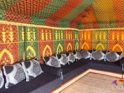 Tente berbère colorée avec coussins noirs, idéale pour un séjour insolite en Aquitaine.