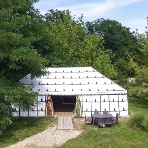 Tente berbère spacieuse entourée de verdure, idéale pour un séjour insolite en Aquitaine.
