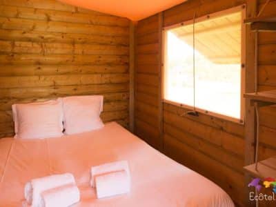 Cabane en bois cosy avec lit double et vue sur la nature en Aquitaine.