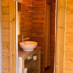 Cabane en bois avec salle de bain moderne et lavabo design en Aquitaine.