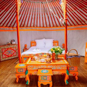 Yourte colorée en Aquitaine, avec lits confortables et table décorative.