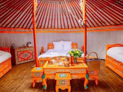 Yourte colorée en Aquitaine, avec lits confortables et table décorative.