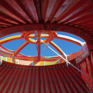 Intérieur coloré dune yourte en Aquitaine, avec un ciel bleu visible par louverture.