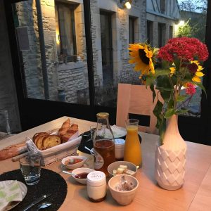 Hébergement insolite en Basse-Normandie avec petit-déjeuner copieux et fleurs colorées.
