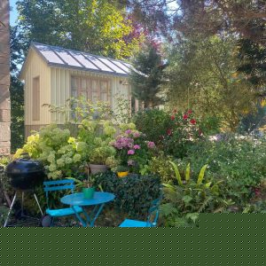 Hébergement insolite en cabane, entouré de fleurs et dun coin repas en plein air.