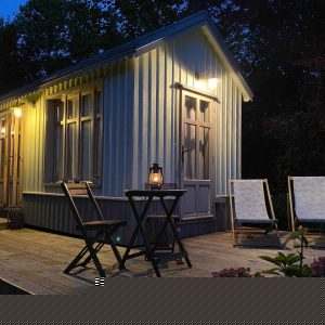 Hébergement insolite en Basse-Normandie : charmante cabane avec terrasse éclairée.
