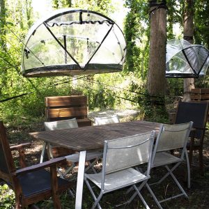 Hébergement insolite en pleine nature : cabanes suspendues et mobilier en bois.