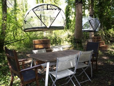 Hébergement insolite en pleine nature : cabanes suspendues et mobilier en bois.