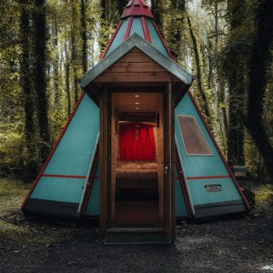 Tente tipi colorée en pleine forêt, offrant un séjour insolite et chaleureux.