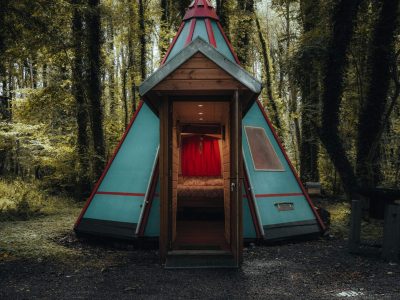 Tente tipi colorée en pleine forêt, offrant un séjour insolite et chaleureux.