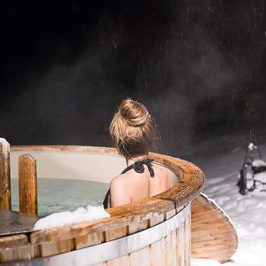 Hébergement insolite en Aquitaine : bain nordique sous la neige, ambiance relaxante.