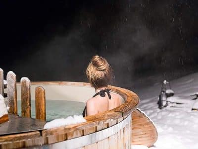 Hébergement insolite en Aquitaine : bain nordique sous la neige, ambiance relaxante.