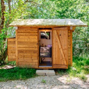 Cabane en bois dans la nature, entourée darbres verdoyants en Aquitaine.