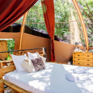 Hébergement insolite en Aquitaine : chambre ronde avec vue sur la forêt et lit douillet.