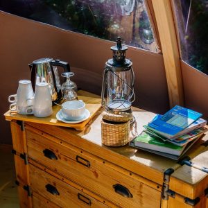 Espace cosy dans une yourte en Aquitaine, avec théière et livres sur une table en bois.