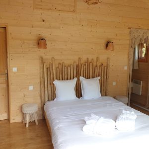 Chalet en bois chaleureux avec lit douillet et décor naturel à Aquitaine.