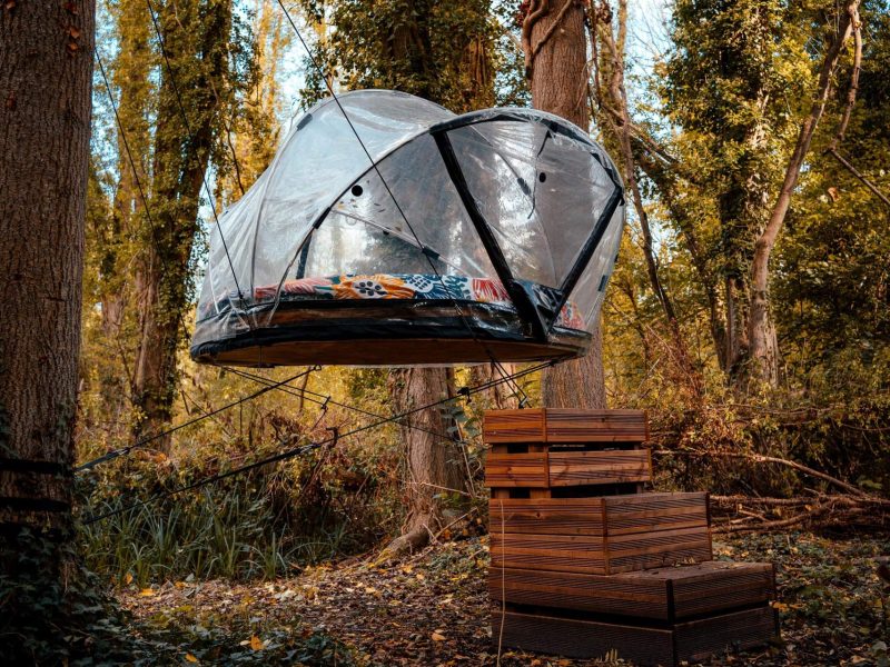 Tente suspendue dans les arbres, offrant une vue unique sur la forêt dÎle-de-France.