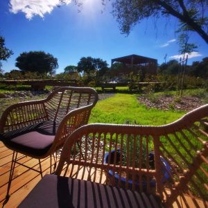 Hébergement insolite en Languedoc-Roussillon, avec chaises en rotin et vue sur la nature.