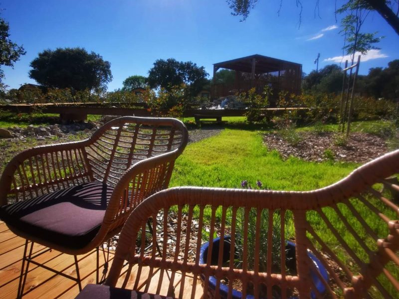 Hébergement insolite en Languedoc-Roussillon, avec chaises en rotin et vue sur la nature.