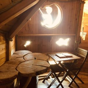 Cabane en bois dans les arbres avec une décoration originale et lumineuse.