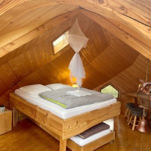 Chalet en bois avec lit douillet et décoration originale en Auvergne-Rhône-Alpes.