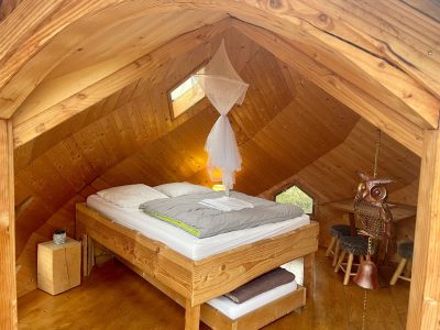 Chalet en bois avec lit douillet et décoration originale en Auvergne-Rhône-Alpes.